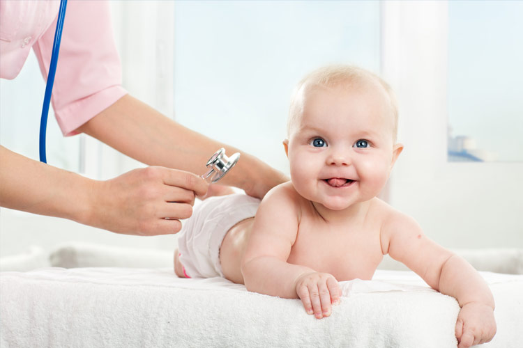 Infant being examined by a nurse with a stethoscope.